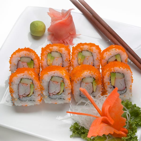 MAJÉ Sushi California rolls with wasabi, ginger, and chopsticks on a white plate.